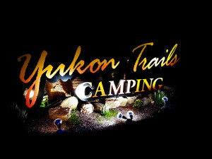 Yukon Trails sign at night.